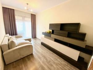 a living room with a couch and a television at Brownie - Neptun Park by OneApartments in Gdańsk