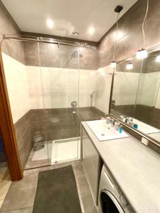 łazienka z prysznicem, umywalką i lustrem w obiekcie Brownie - Neptun Park by OneApartments w Gdańsku +8 zdjęć