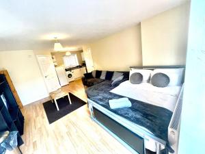 a bedroom with a large bed and a living room at Lt Properties Studio apartment Ground floor 3 in Luton