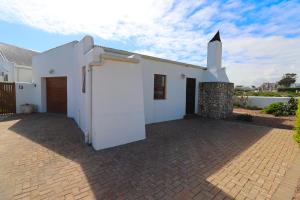 a white church with a brick driveway at Hallo Jacobsbaai in Jacobs Bay