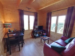 a living room with a couch and a desk in a cabin at Skye Coorie Cabin in Breakish