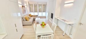 a white living room with a table and a couch at Cozy White Home in Getxo in Getxo