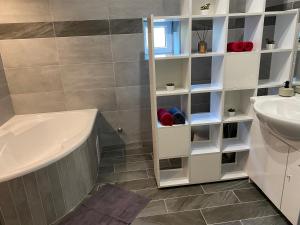 W łazience znajduje się wanna, umywalka i wanna. w obiekcie BNCK Wellness Residence w mieście Sátoraljaújhely