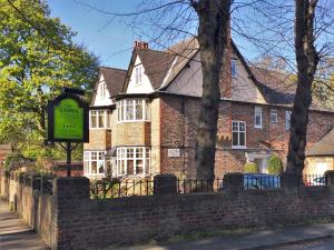 une maison en briques avec un panneau devant elle dans l'établissement The Limes, à York