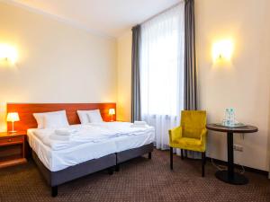 una camera d'albergo con letto e sedia gialla di Villa Anna Lisa a Świnoujście
