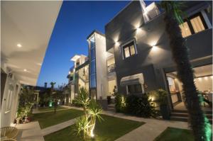 a large black building with a palm tree in front of it at Villa Irina sea view in Sykia Chalkidikis