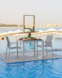 a table and chairs on a floating table in the water at C Central Hotel and Resort The Palm in Dubai