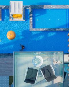 a painting of a pool with a table and a chair at C Central Hotel and Resort The Palm in Dubai