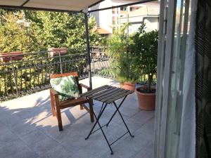 una silla sentada en un patio con sombrilla en Appartamento con terrazza e posto auto Libri e Giardini, en Pero