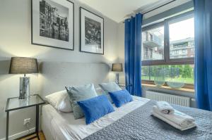Schlafzimmer mit einem Bett mit blauen Vorhängen und einem Fenster in der Unterkunft EXCLUSIVE FORTY Apartments in Stettin