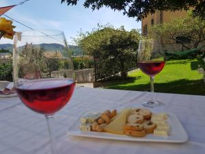 una mesa con un plato de queso y dos copas de vino en Casa Rural Basaula, en Muneta