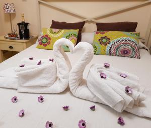 two swans towels sitting on a bed with flowers at Casa Rural Basaula in Muneta