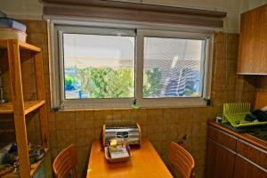 uma cozinha com uma janela e uma mesa com um liquidificador em Cozy Urban Apartment at Agios Dimitrios em Atenas