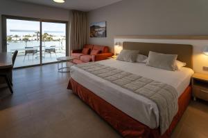 a bedroom with a large bed and a living room at Hotel Lanzarote Village in Puerto del Carmen