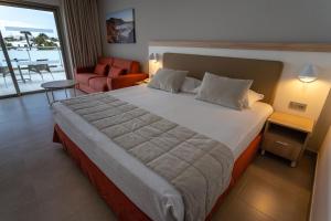 a bedroom with a large bed and a living room at Hotel Lanzarote Village in Puerto del Carmen