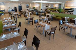 a restaurant with tables and chairs and a cafeteria at Hotel Lanzarote Village in Puerto del Carmen