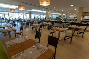 a restaurant with wooden tables and chairs and a bar at Hotel Lanzarote Village in Puerto del Carmen