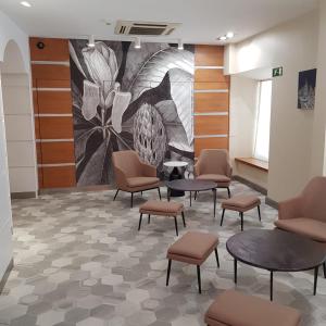 a waiting room with chairs and tables and a mural at Ateneo Puerta del Sol in Madrid