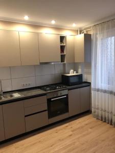 een keuken met witte kasten en een fornuis met oven bij Квартира студия in Izmail
