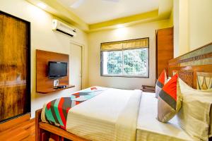 a bedroom with a large bed and a television at FabHotel Nandanvan in Pune