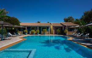 a swimming pool with chairs and a house at Villaggio Maistro in Lefkada