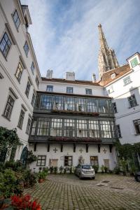 ein großes Gebäude mit einem davor geparkt in der Unterkunft Gästehaus Deutscher Orden Wien in Wien