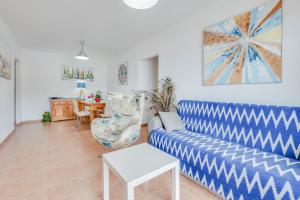 a living room with a blue couch and a table at Apartamento Superior in Candelaria