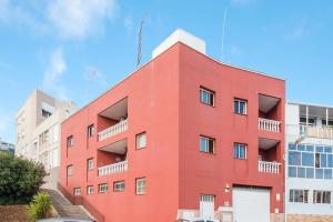 een rood gebouw met balkons erop bij Three bedroom apartment ii near Sc in Bocacangrejo