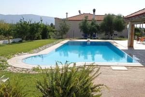a swimming pool in a yard with a house at Villa IRENE Evia, 4 bdr, Pool, 500m to Beach in Magoúla