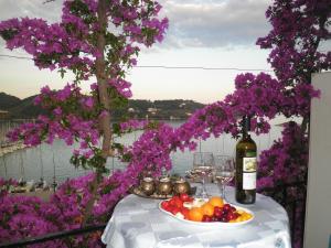 una mesa con una bandeja de fruta y una botella de vino en Babis en Skíathos