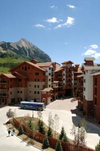 un autobús estacionado en un estacionamiento frente a los edificios en The Lodge at Mountaineer Square en Mount Crested Butte