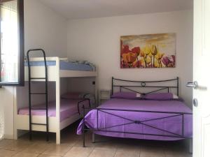 1 Schlafzimmer mit 2 Etagenbetten mit lila Bettwäsche in der Unterkunft Appartamento con Piscina a Lazise in Lazise