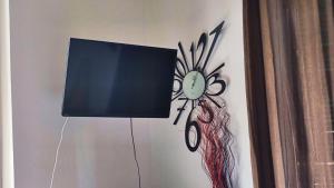 een tv aan een muur met een schilderij van een klok bij Urban central Florence in Florence
