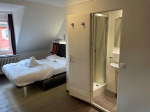 a small bedroom with a bed and a bathroom at easyHotel Zürich Limmatplatz in Zurich