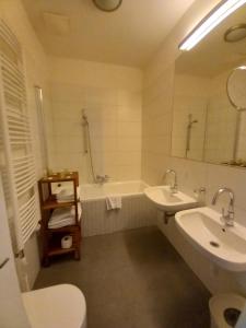 a bathroom with a sink and a tub and a toilet at James Hotel & Apartments in Prague +34 photos