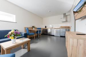 una cucina e un soggiorno con tavolo e sedie di Droomvakanties Egmond Appartement van Speijk a Egmond aan Zee