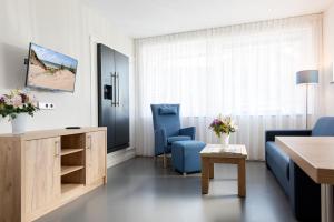 sala de estar con 2 sillas azules y mesa en Droomvakanties Egmond Appartement van Speijk, en Egmond aan Zee