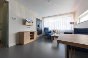 un soggiorno con tavolo e sedie blu di Droomvakanties Egmond Appartement van Speijk a Egmond aan Zee