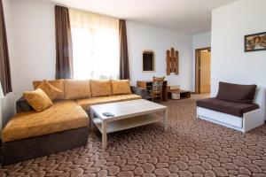 Una sala de estar con un sofá y una mesa de café. en Family Hotel Panorama, en Chiflik
