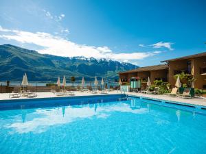 a hotel swimming pool with mountains in the background at Hotel Leonardo Da Vinci in Limone sul Garda