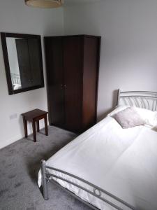 a bedroom with a bed and a wooden cabinet at Stylish Private Double Room w/ensuite in London