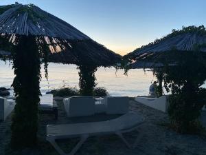 una spiaggia con sedie e ombrelloni di Apartments Biserka a Punat