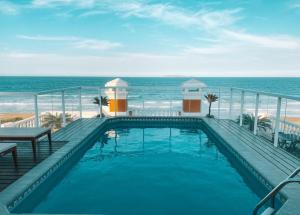 a swimming pool with the ocean in the background at Pousada Villa dos Açores in Bombinhas