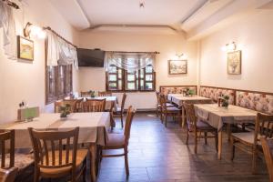 Un restaurante con mesas y sillas y una ventana. en Family Hotel Panorama, en Chiflik