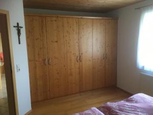 1 dormitorio con un gran armario de madera con una cruz en la pared en Ferienwohnung Pauli en Zwiesel