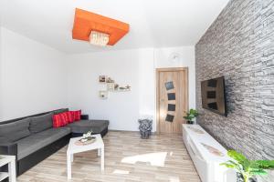 a living room with a couch and a brick wall at Apartment Marino in Kaštela