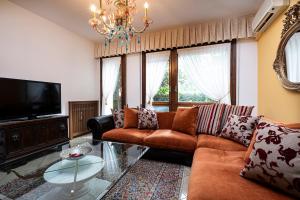 a living room with a couch and a tv at Villa Terme Padova-Relax & Wellness in Selvazzano Dentro