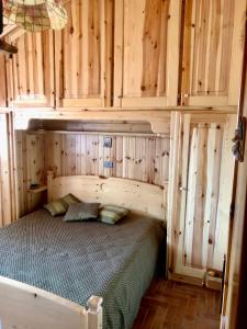 a bedroom with a bed with wooden walls and cabinets at Casa serenaurora in Castel di Sangro