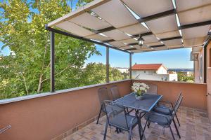 a patio with a table and chairs on a balcony at Apartment Marino in Kaštela