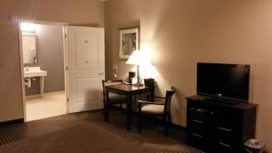 a hotel room with a desk and a television and a room at Atria Inn & Suites in Three Rivers